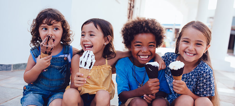 four young children eating ice cream together