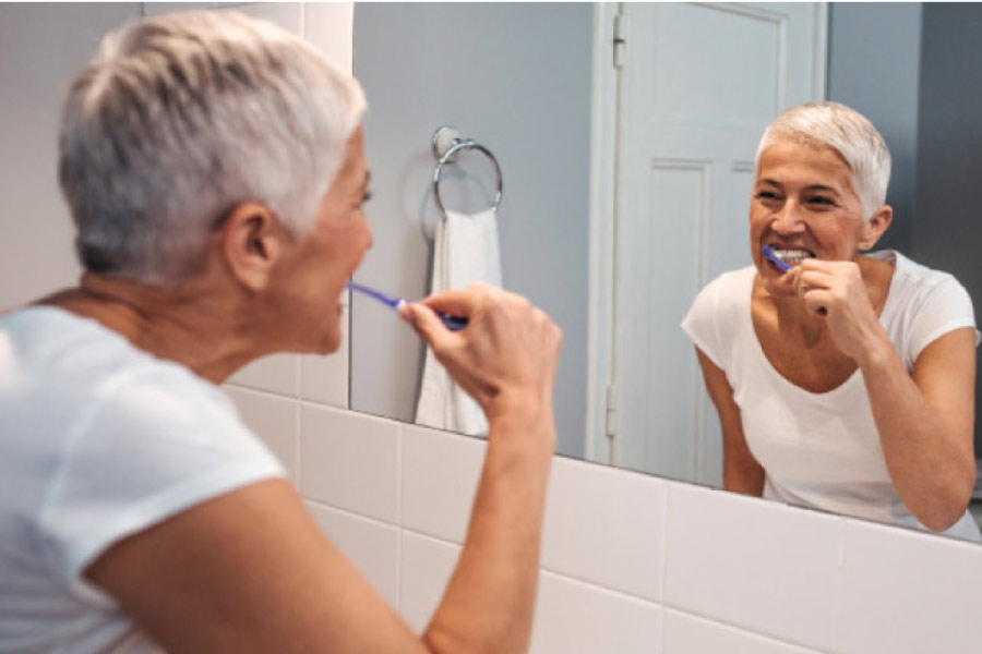 woman brushes her teeth in the morning