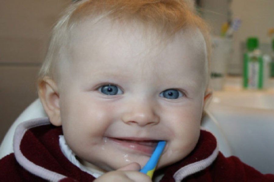 baby boy with a toothbrush in his mouth